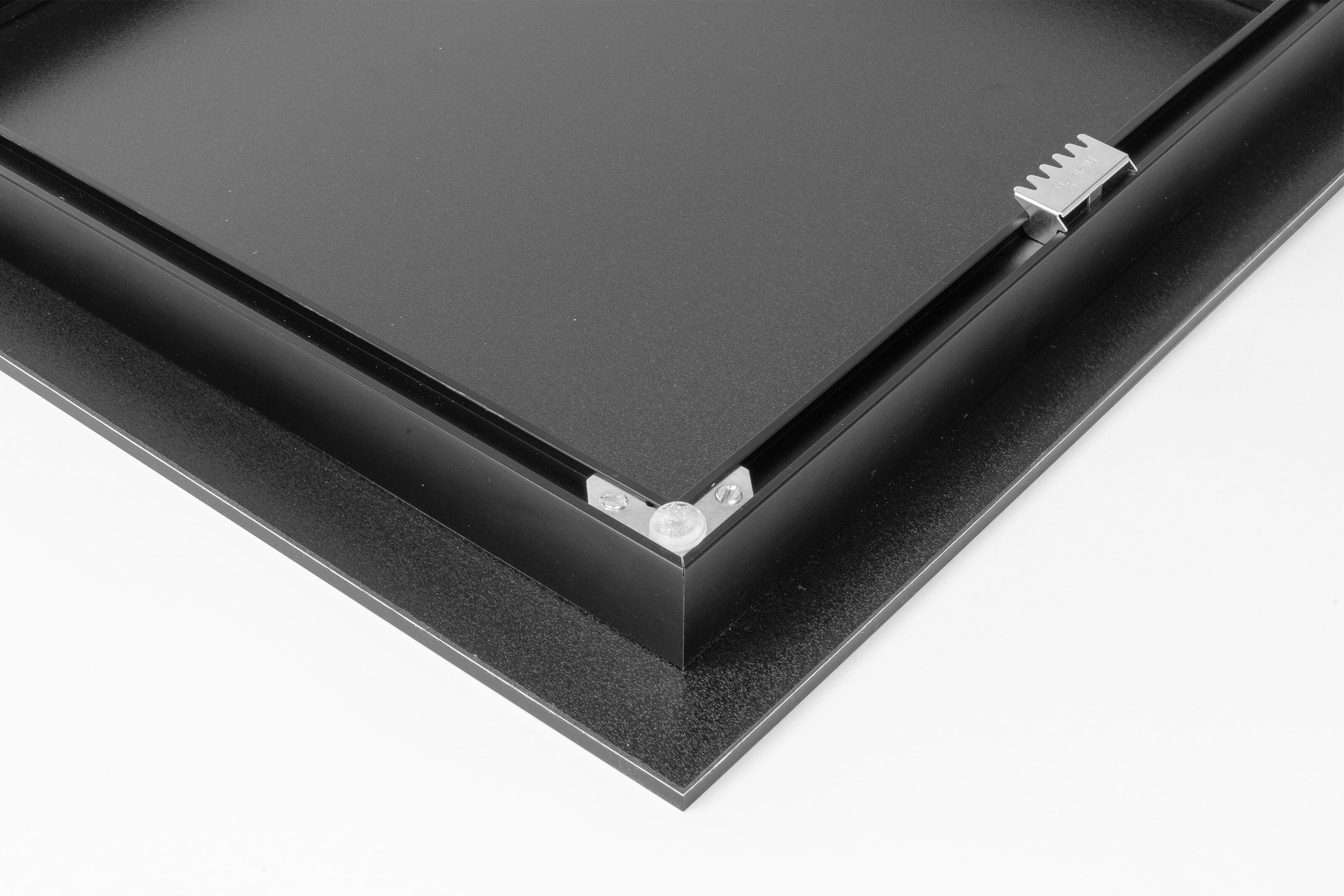 back of an acrylic print with an inset metal frame with sawtooth hanger