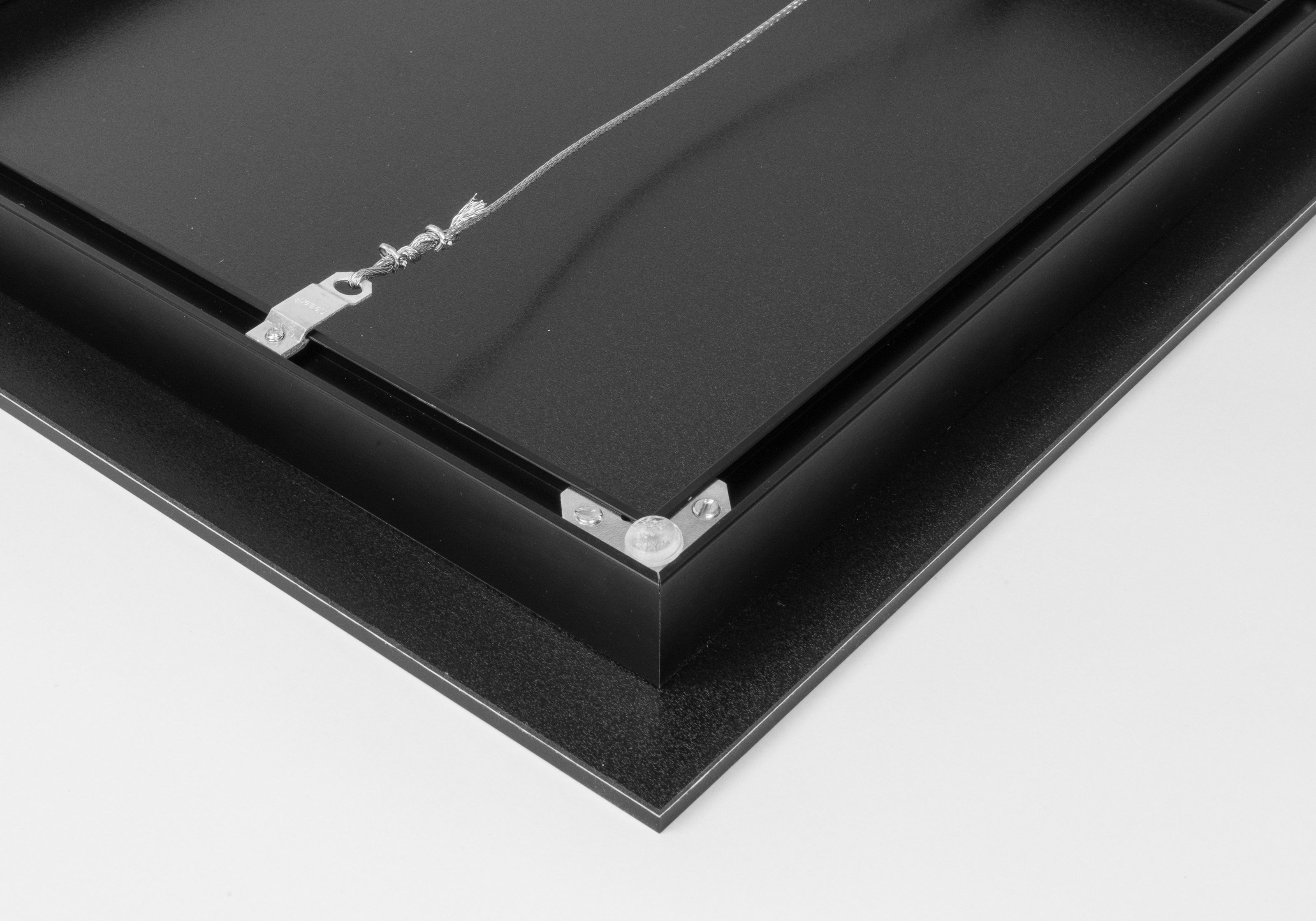 back of an acrylic print with an inset metal frame with wire hanger