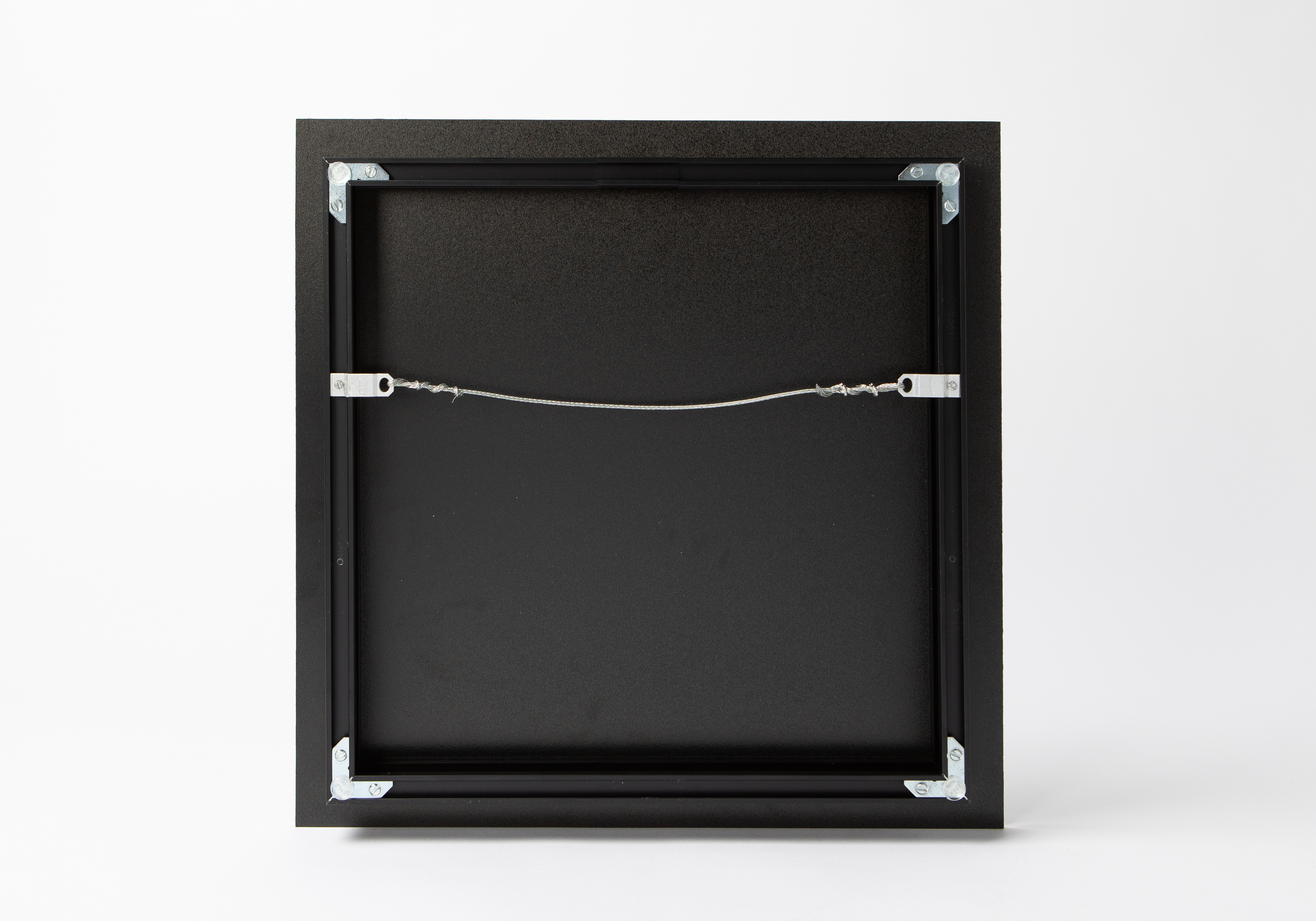 back of an acrylic print with an inset metal frame with wire hanger