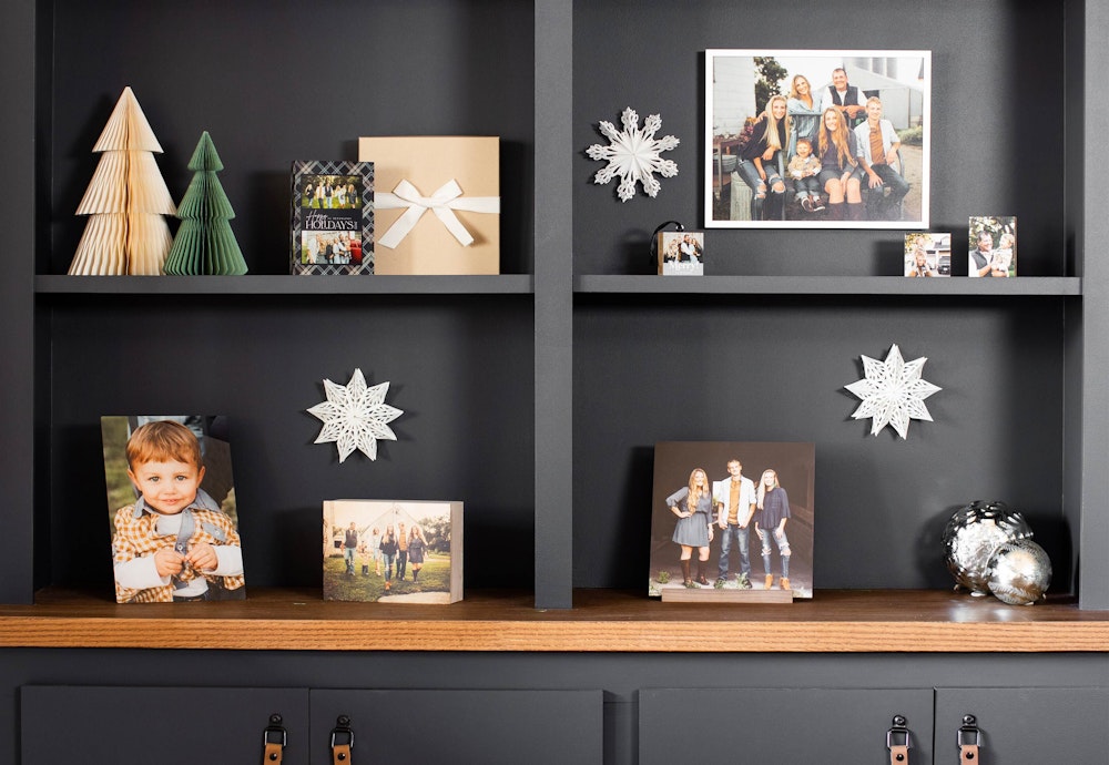 Black bookshelf filled with client gifts—frames, acrylic blocks, wood box, bamboo mini blocks