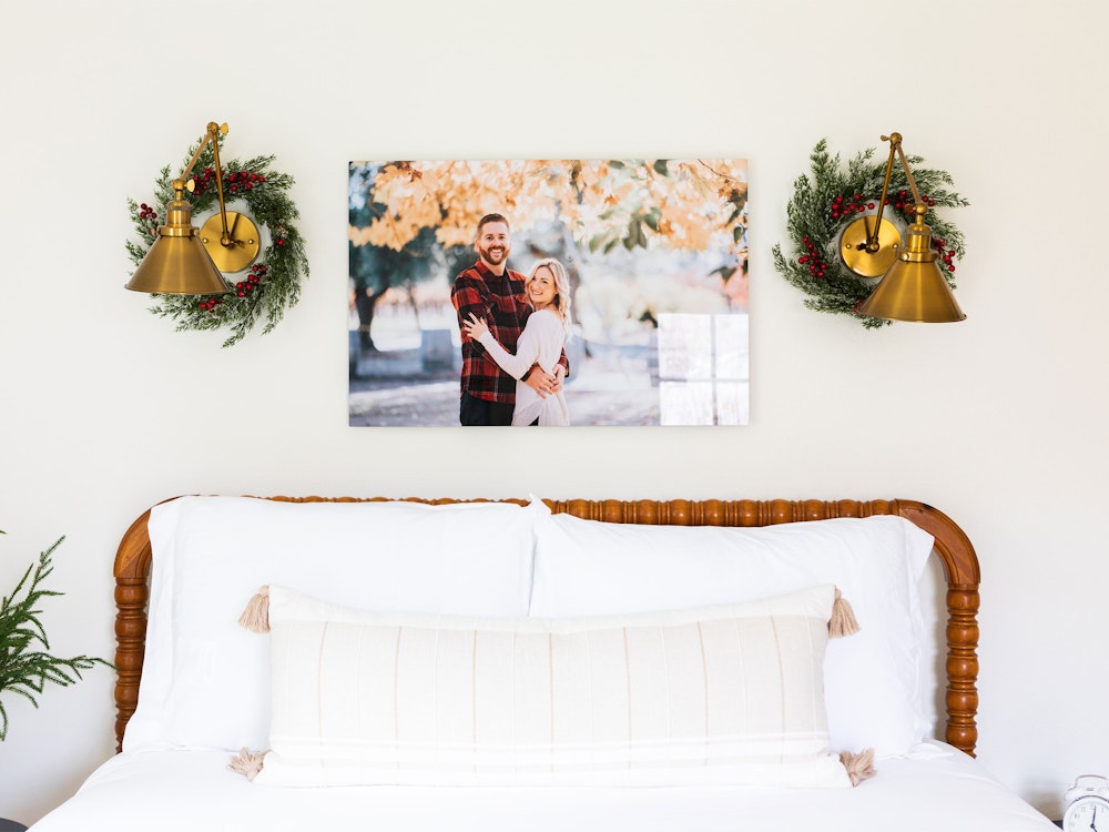 Engagement portrait high gloss Metal Print above bed with holiday wreath styling in bedroom