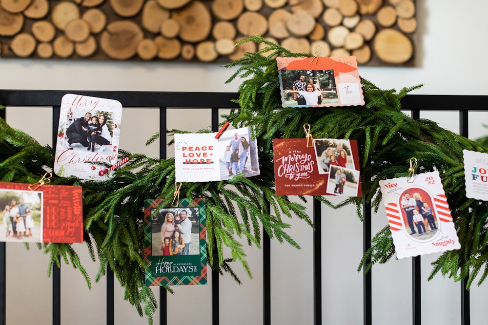 Holiday Flat Cards hanging on greenery along stair railing