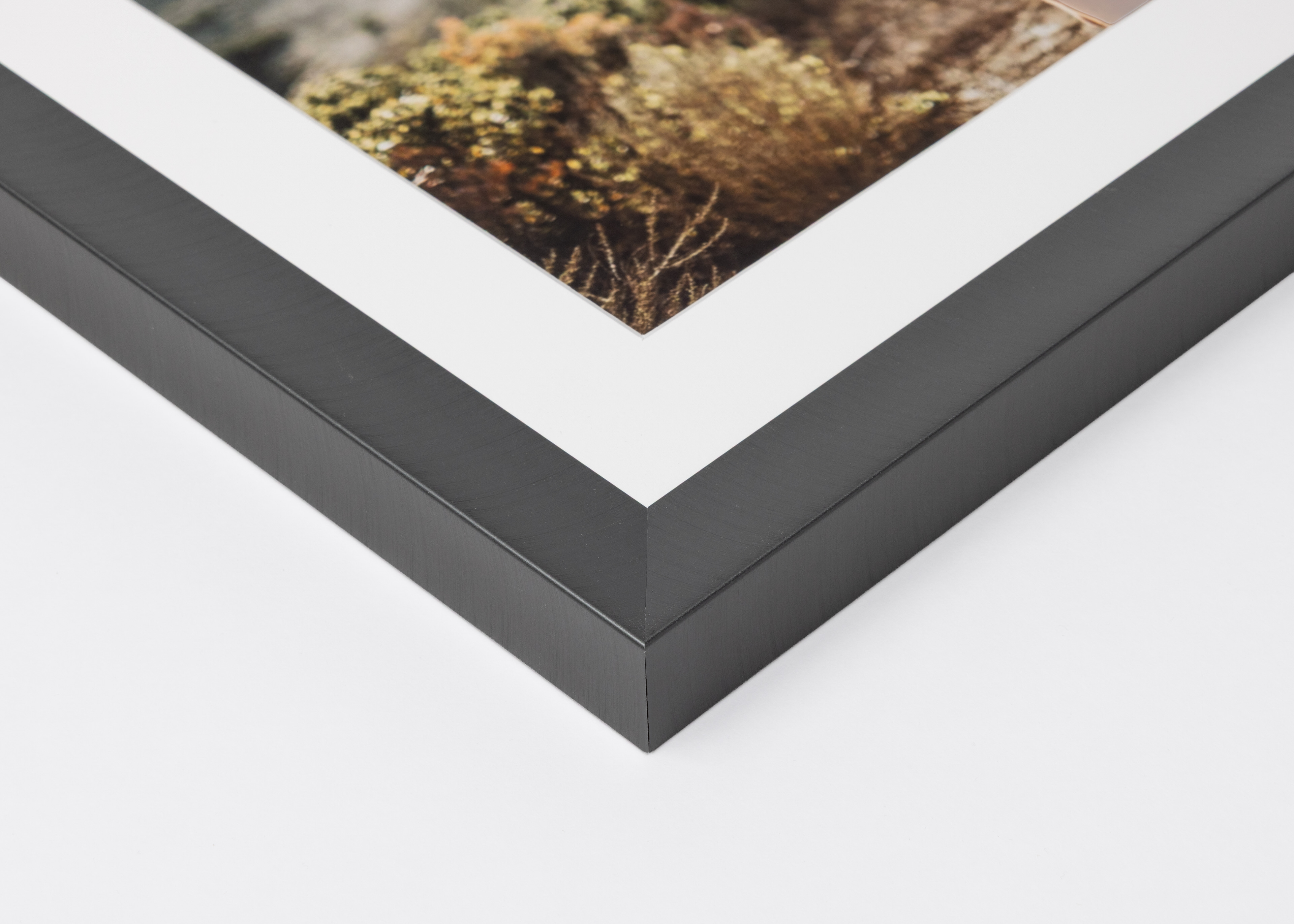 Close-up corner of a Graphite Metal Framed Print moulding on a white background