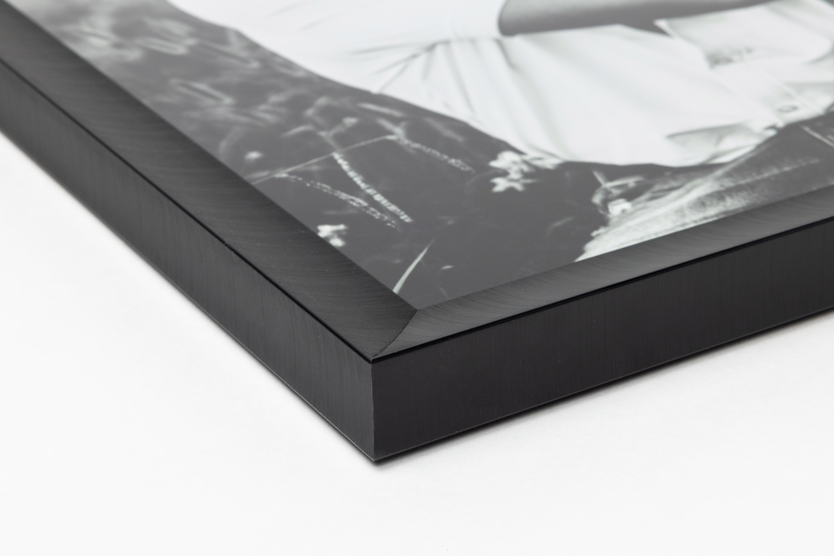 Close-up corner of a Jet Black Metal Framed Print moulding on a white background