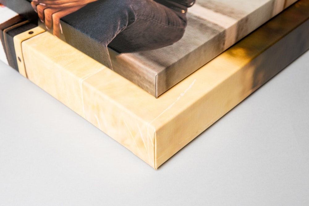 Two Premium Gallery Wraps, one 1½" and the other 2½" depth, stacked on each other, lying on a light gray background