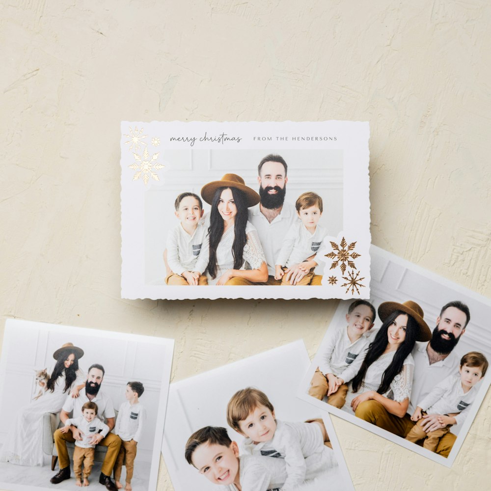 Gold foil snowflake design on the corners of a 5x7 holiday Flat Card that reads "Merry Christmas from the Hendersons" and features professional family portraits in a modern studio