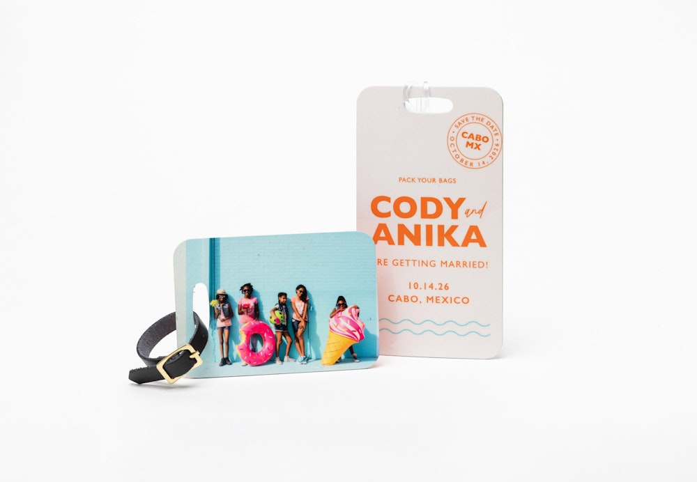 Colorful children's portrait printed on a small Bag Tag with a black leather strap, and a destination wedding design on a large Bag Tag with a clear plastic strap, standing on a white background.