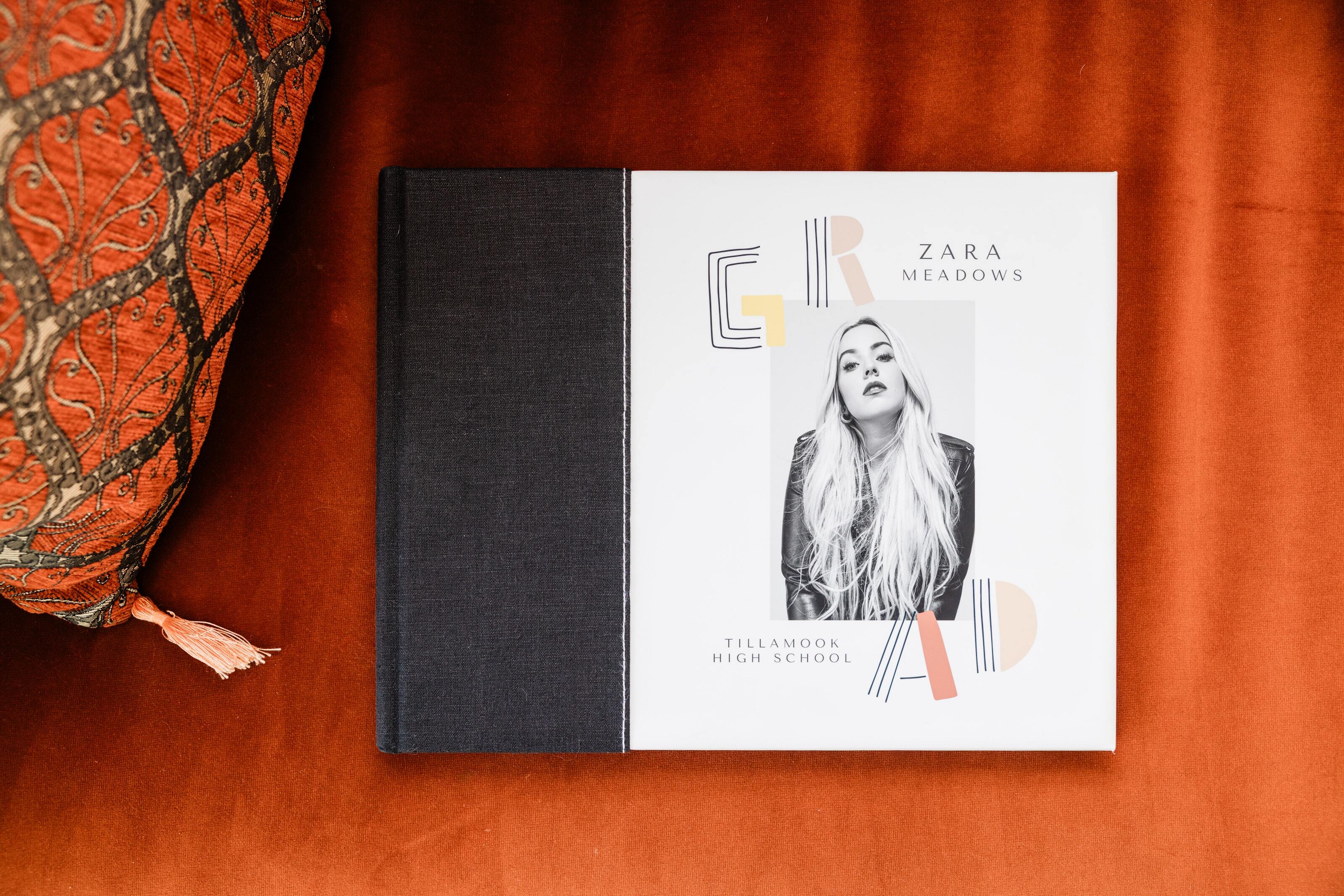 Layflat graduation Book with Black Bookcloth Combo Cover featuring a senior portrait and geometric 'GRAD' lettering.