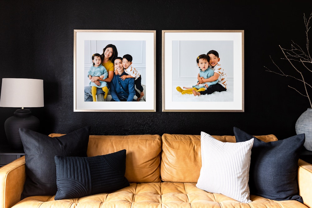 Large family portrait Framed Prints hanging above couch on black wall