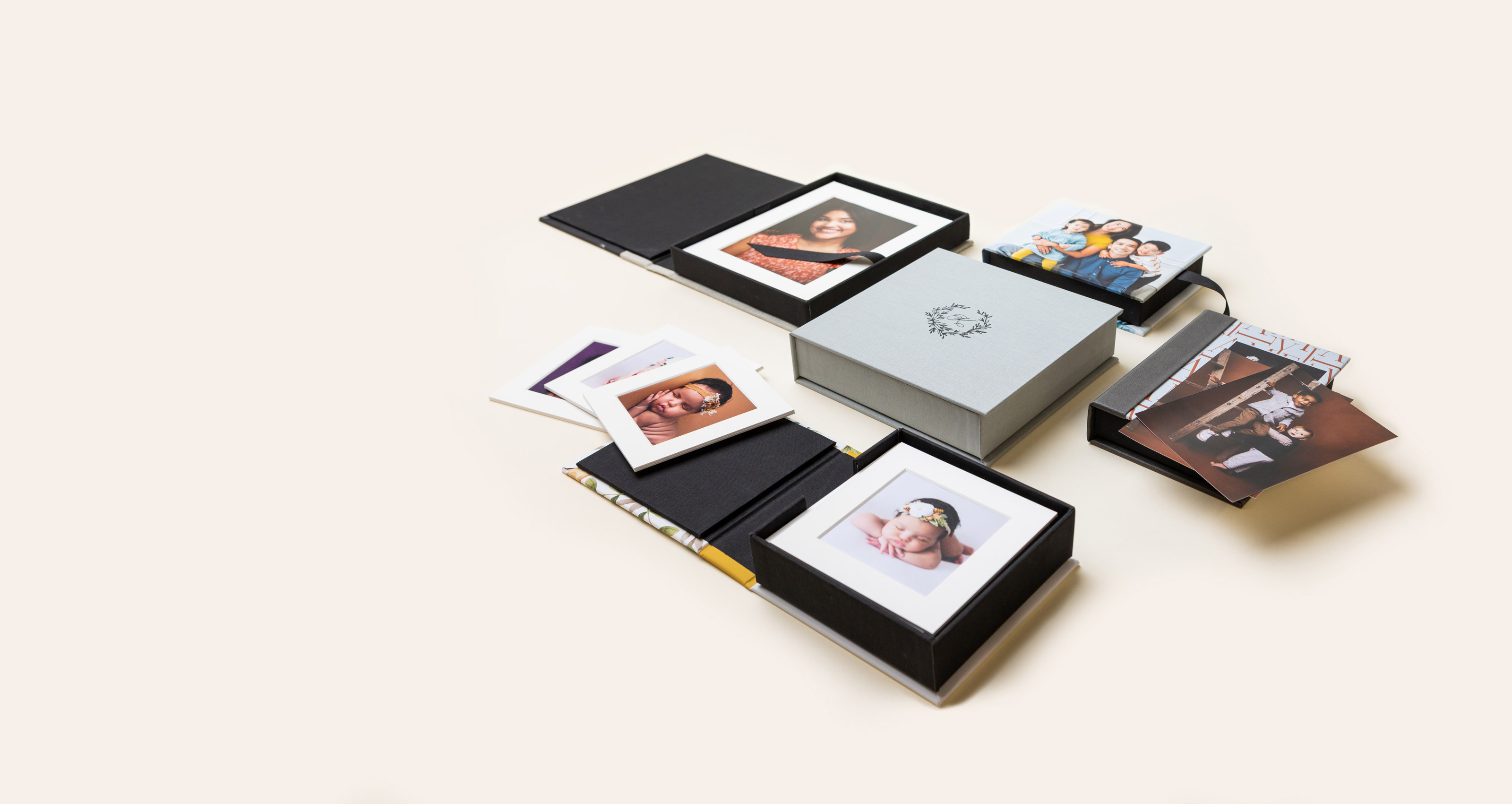 Several 3-Panel Print Boxes arranged on cream background, featuring debossed material and photo covers featuring imagery from various portrait photography sessions.