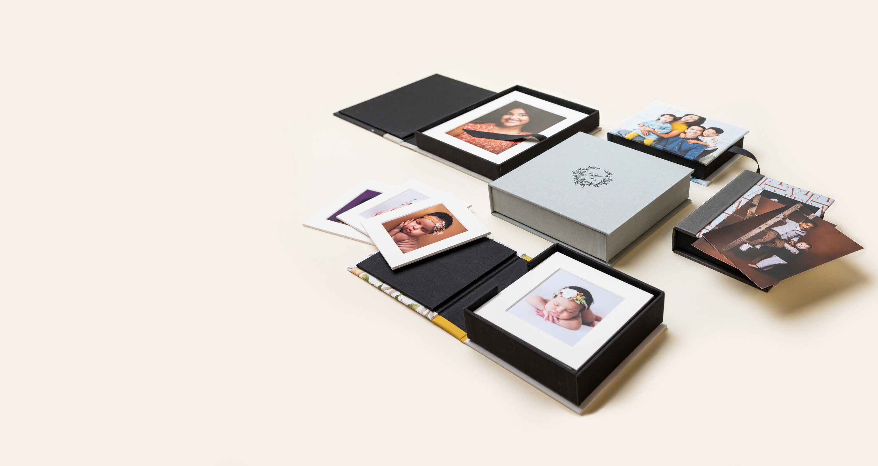 Several 3-Panel Print Boxes arranged on cream background, featuring debossed material and photo covers featuring imagery from various portrait photography sessions.