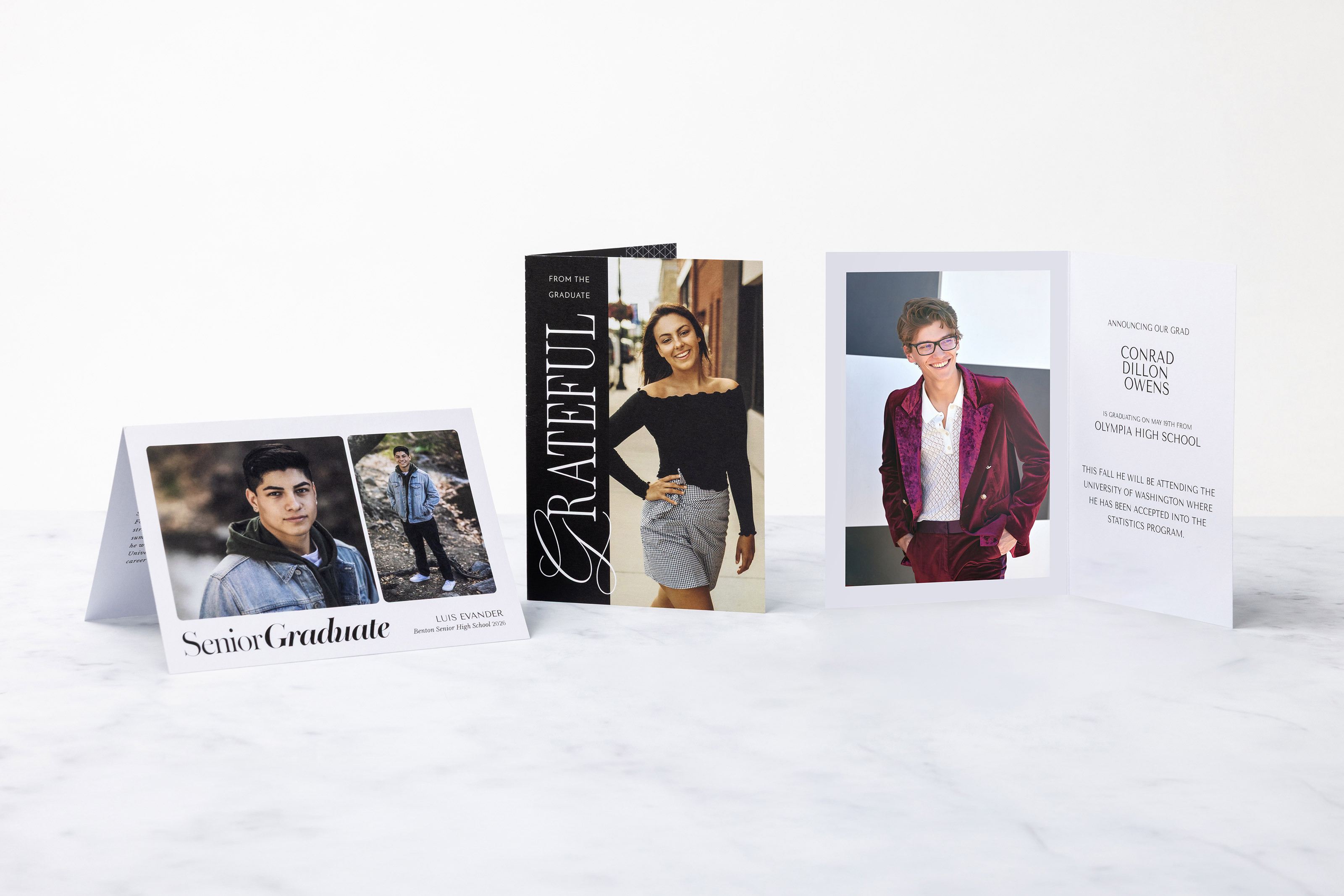 One horizontal and two vertical Folded Cards standing on on a marble background featuring various senior graduation invitation and thank you card designs.