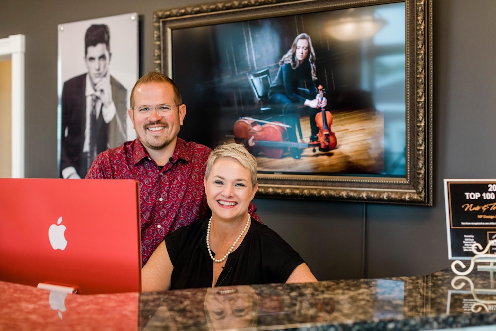 Nate & Teresa Peterson at desk before their photography studio makeover