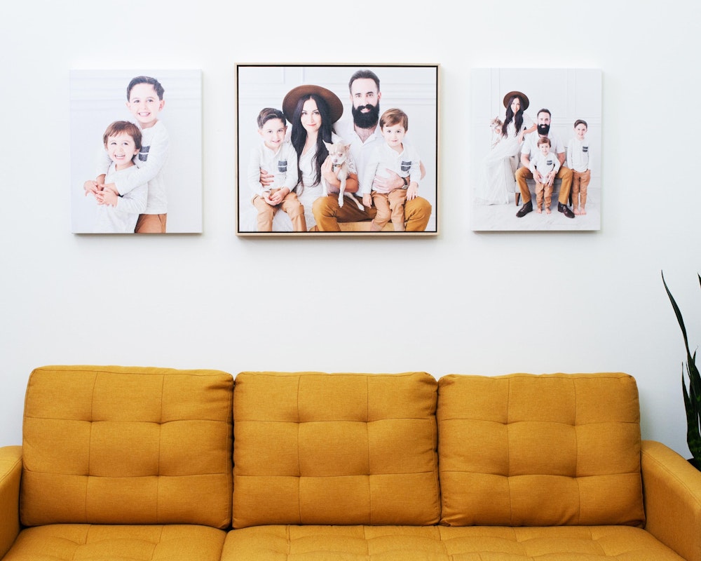 Float Frames & Gallery Wraps Wall Groupings hanging over yellow couch