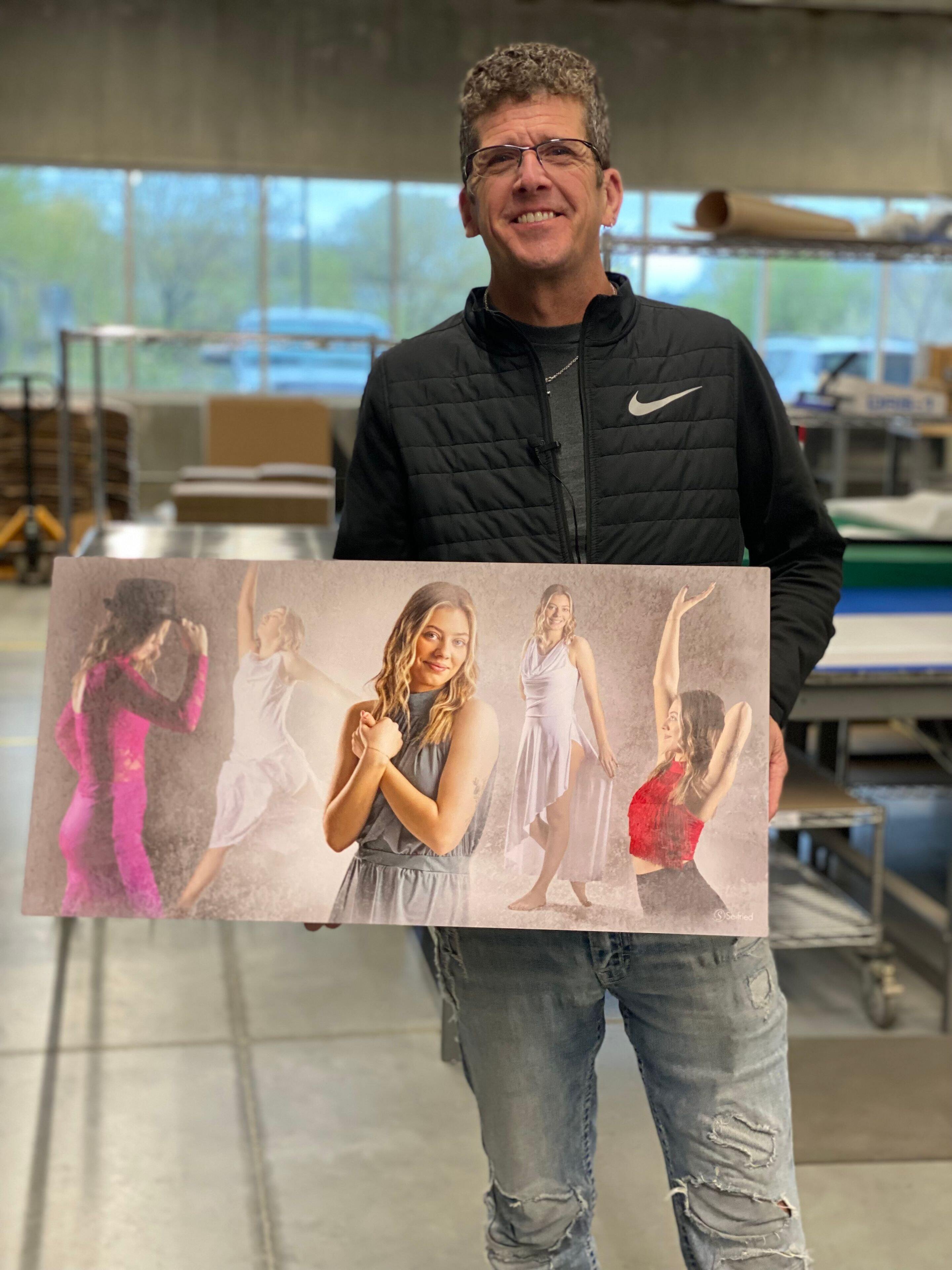 Steve Seifried of Seifried Portrait Design holding one of his prints during a visit to the WHCC lab