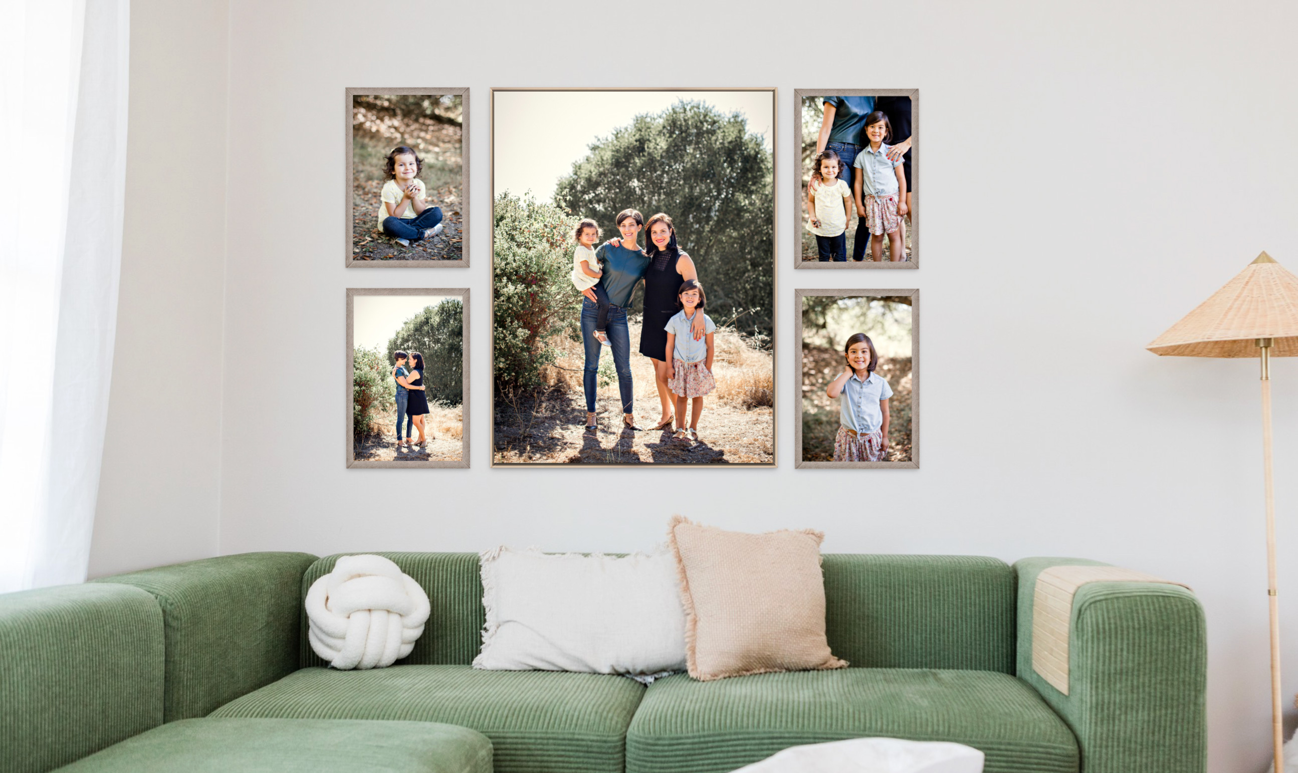 Large central Float Frame with two smaller Framed Prints on each side feature family portraits session photography hung over a green sectional couch with accent pillows and a tan wicker lamp