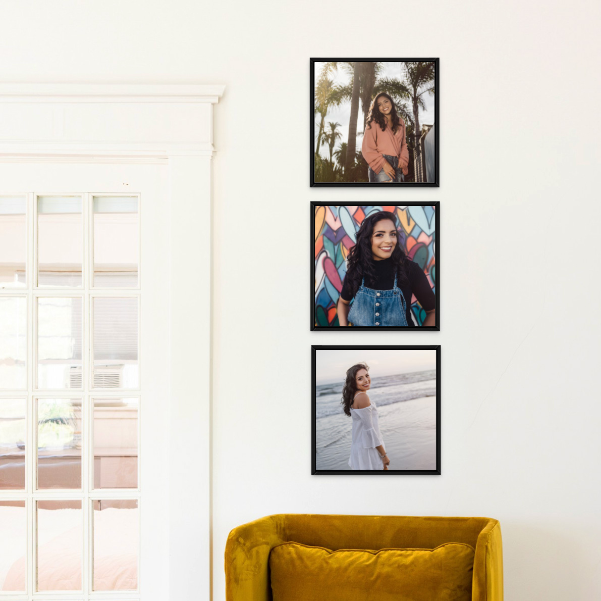 Three Classic Black Flat Frames with senior graduation portraits stacked on a wall above a goldenrod colored armchair.