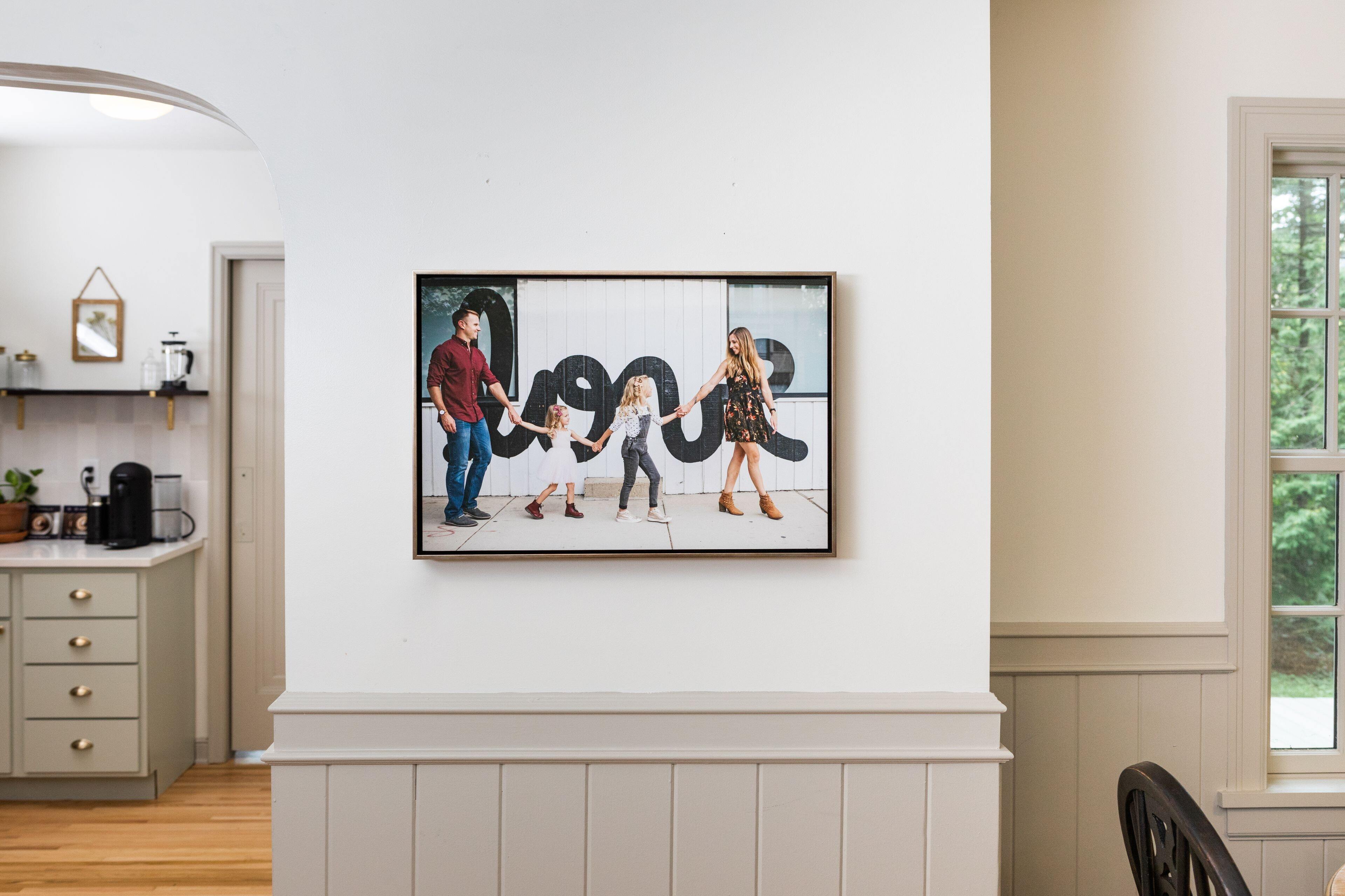 Family portrait in an Aged Metallic Float Frame on a white wall beside a kitchen doorway