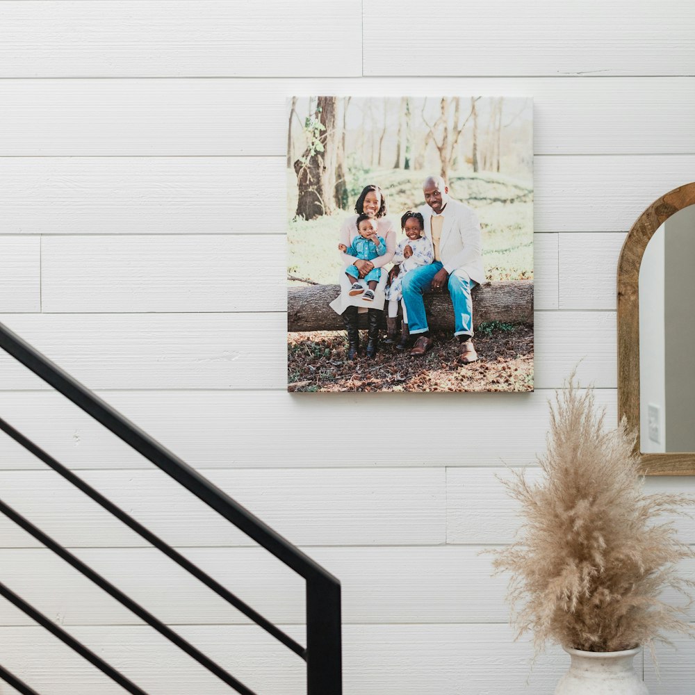 Family portrait Gallery Wrap hanging on white wood paneled staircase wall