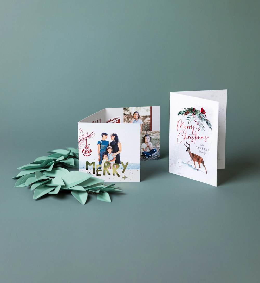 5x7 Folded and 5x5 Trifold Cards with holiday designs on green background with paper garland