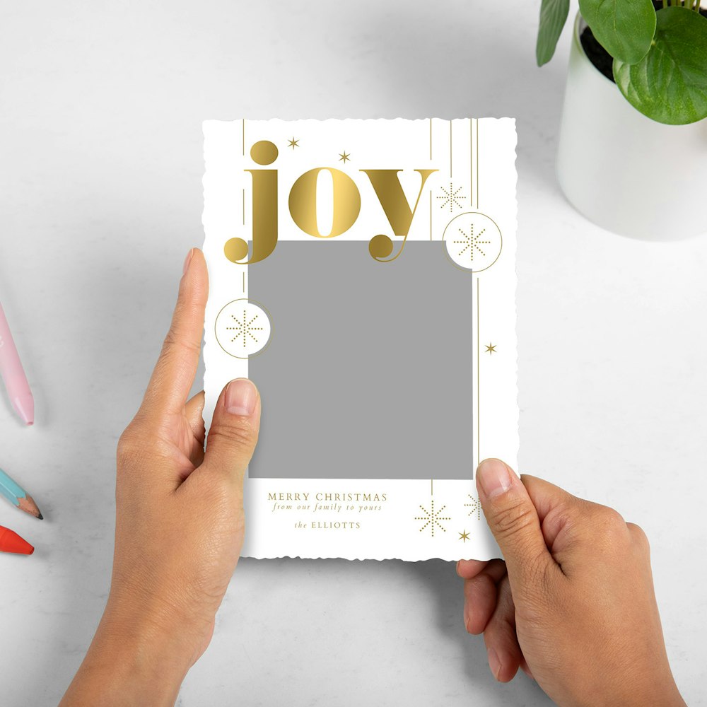 Whcc holiday card Joy bold sparkles Styled With Pens and Plant Model2 article