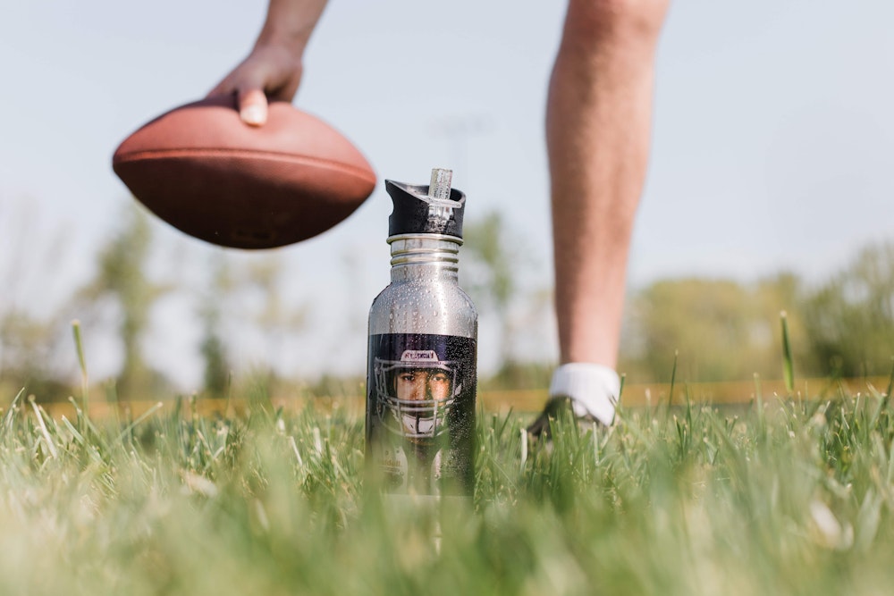 Hand setting down football behind sports photo printed water bottle