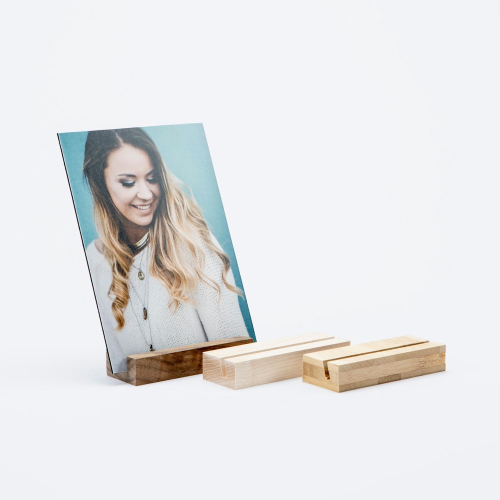 Senior portrait of a smiling girl with long hair printed on a Mounted Photographic Print in a Wood Display Stand with other styles of stands arranged around it