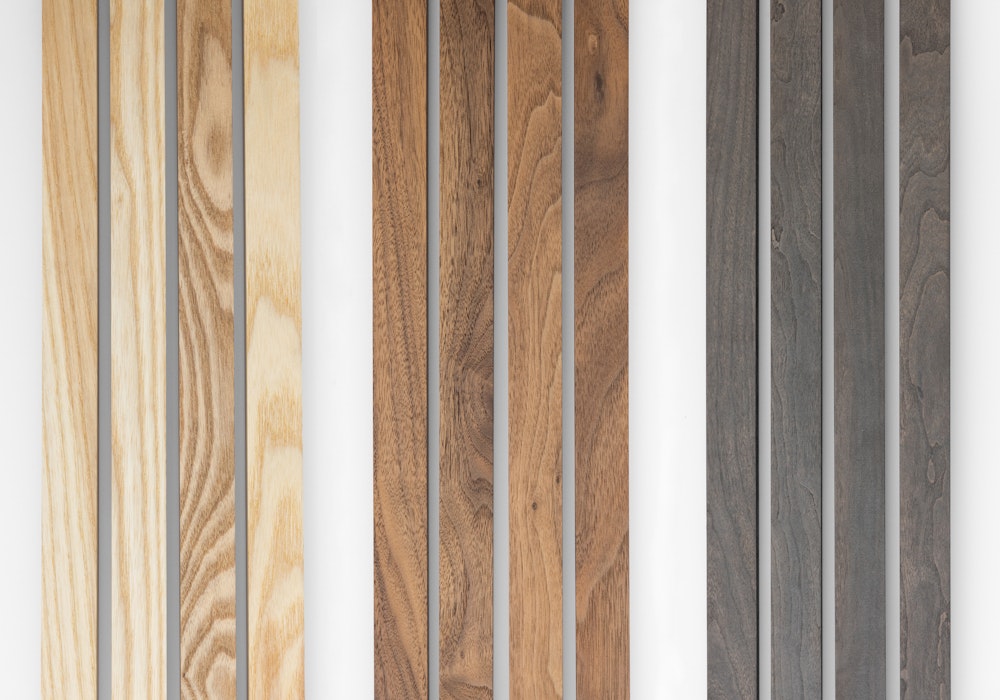 Four natural, walnut, and gray Woodland frame sticks lying next to each other showcasing variations in wood grain and color